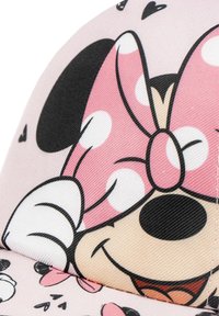 Cappello rosa con un personaggio dei cartoni animati e un fiocco a pois. Il tessuto ha una superficie liscia, con accenti in bianco e nero e motivi a cuori.