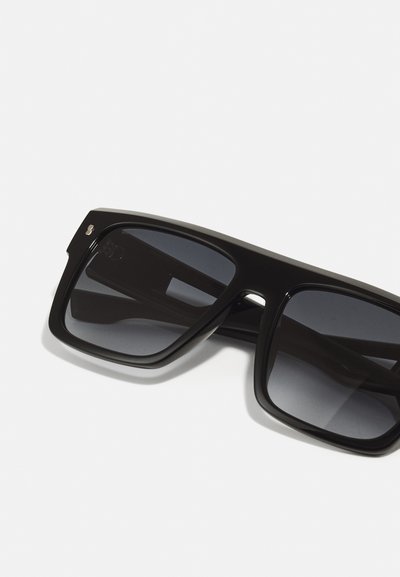 Occhiali da sole neri con montatura quadrata, lenti scure e finitura lucida. Dettagli notevoli includono un design minimalista e un marchio discreto sulla montatura.