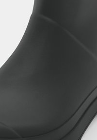 CI^l^1=cu negru din cauciuc cu o suprafață netedă, mată, cu formă rotundă și fără hardware sau model vizibil. Conceput pentru a rezista la apă.