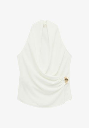 Weiße ärmellose Bluse mit drapiertem Vorderteil, weichem Stoff und einem dekorativen goldfarbenen Metallakzent an der Seite, der einen sanften Fluss erzeugt.