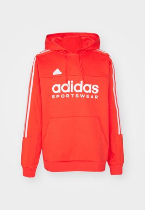 Rode Adidas hoodie met een voorste kangoeroezak, wit logo en drie witte strepen op elke mouw. Gemaakt van zachte stof. Voorzien van een capuchon met koord.