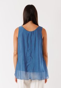 Top blu, leggero e senza maniche con scollatura arrotondata e vestibilità ampia. Tessuto semitrasparente con una texture liscia e una leggera lucentezza.