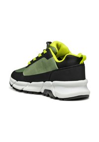 Scarpa sportiva nera e verde con tomaia texturizzata, design leggero, suola intermedia bianca e suola in gomma spessa. Lacci e dettagli in giallo neon.