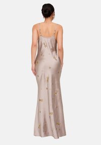 Langes Lavendel-Satin-Kleid mit dünnen Trägern. Verziert mit gestickten goldenen Akzenten und dekorativen Perlenmustern. Glatte Textur.