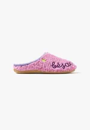 Pantofole rosa colorate e pelose con una superficie testurizzata, accentuazione viola sul retro e la scritta "bésar" stampata in viola scuro. Dettaglio verde vicino alla punta.