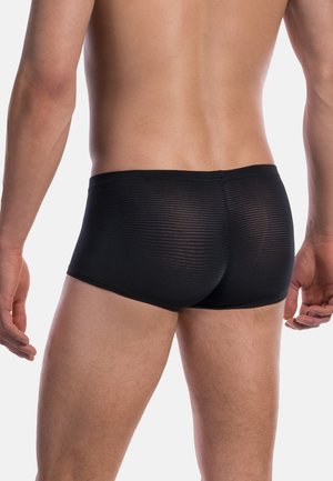 Boxers noirs avec une texture côtelée et un design ajusté. La ceinture est lisse et le tissu paraît léger et extensible.