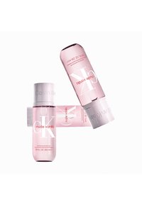 Three pink bottles of CK Nude Vanilla, cylindrical shape, clear labels with white and red text, and glossy caps, displaying water droplets.
