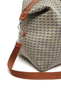 Kangaskassi, jossa on beige, sininen ja ruskea väri sekä geometrinen kuvio. Mukana ruskea olkahihna, metallikoristeita ja vetoketjusuljenta.