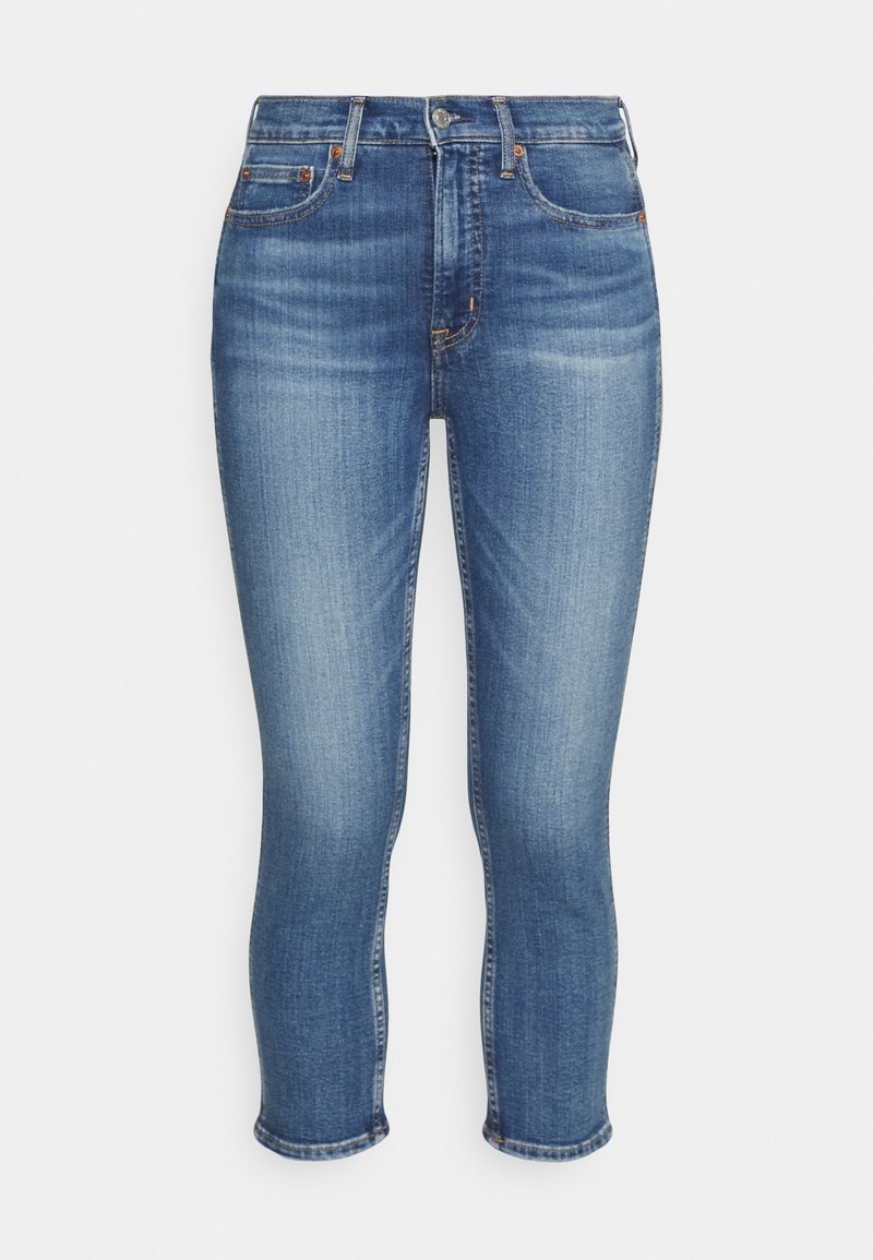 Jean skinny taille haute bleu avec bouton et fermeture éclair à l'avant, cinq poches et détails subtils délavés sur les cuisses et les genoux.