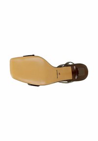 Semelle d'une sandale brune pour femme avec bout carré, talon de hauteur moyenne, et le nom de la marque Wojas en taille 38 visible sur la semelle.