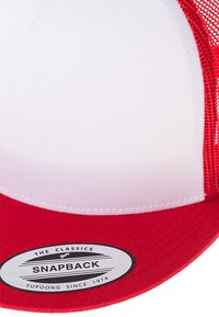 Crvena snapback kapa s bijelom prednjom pločom, mrežastom stražnjom stranom, ravnim vizonom i ovalnom etiketom s natpisima "THE CLASSICS" i "YUPONG SINCE 1974."