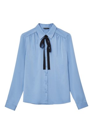 Blouse bleu clair à manches longues, fermeture à boutons, col classique et un nœud en ruban noir au cou. Texture lisse, semblable à du satin.