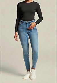 High-waisted blue jeans with a slim fit and subtle fading, paired with a black long-sleeve top and white sneakers.