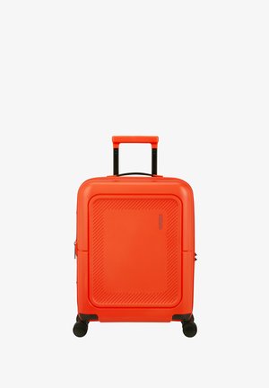 Valigia rigida di un brillante colore arancione con quattro ruote girevoli nere e manico telescopico estensibile, eretta su sfondo bianco.