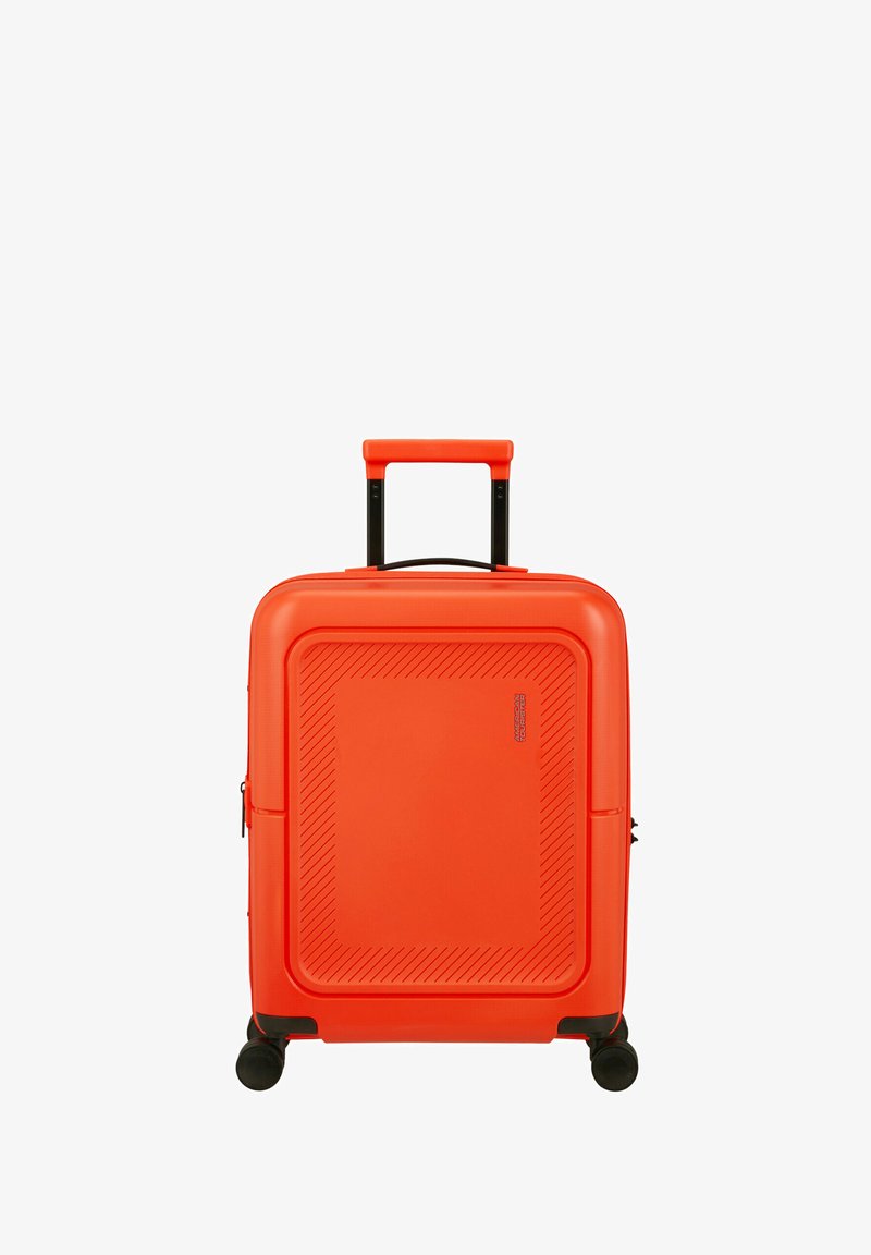 Valigia rigida di un brillante colore arancione con quattro ruote girevoli nere e manico telescopico estensibile, eretta su sfondo bianco.