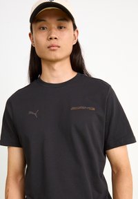 Puma AMG GRAPHIC TEE - Apdrukāts T-krekls - black