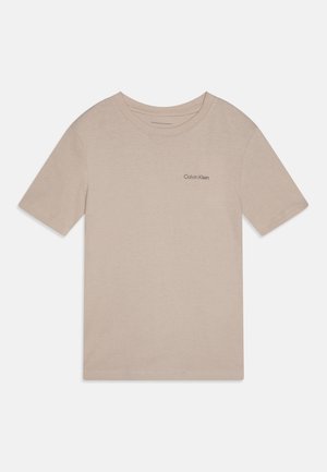Heledad beez t-särk lühikeste varrukatega, ümar kaelus ja vasakul rinnal väike must "Calvin Klein" logo. Sile puuvillane kangas.