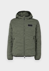 Quilted hooded jacket in olive green with a zip closure, side pockets, and a black fabric patch on the chest. Textured surface detail.