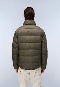 Olive green puffer jacket with a high collar, featuring horizontal quilted panels and a smooth texture, paired with cream cargo pants.