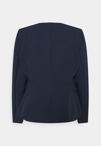 Blazer ajusté bleu marine à manches longues, avec une silhouette structurée et de subtiles poches latérales. Texture lisse et détails de conception minimalistes.