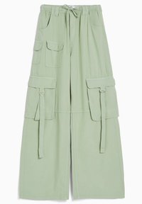 Ljust gröna cargobyxor med elastisk midja, dragsko, två stora sidofickor och vida ben med fästa tygremmar.