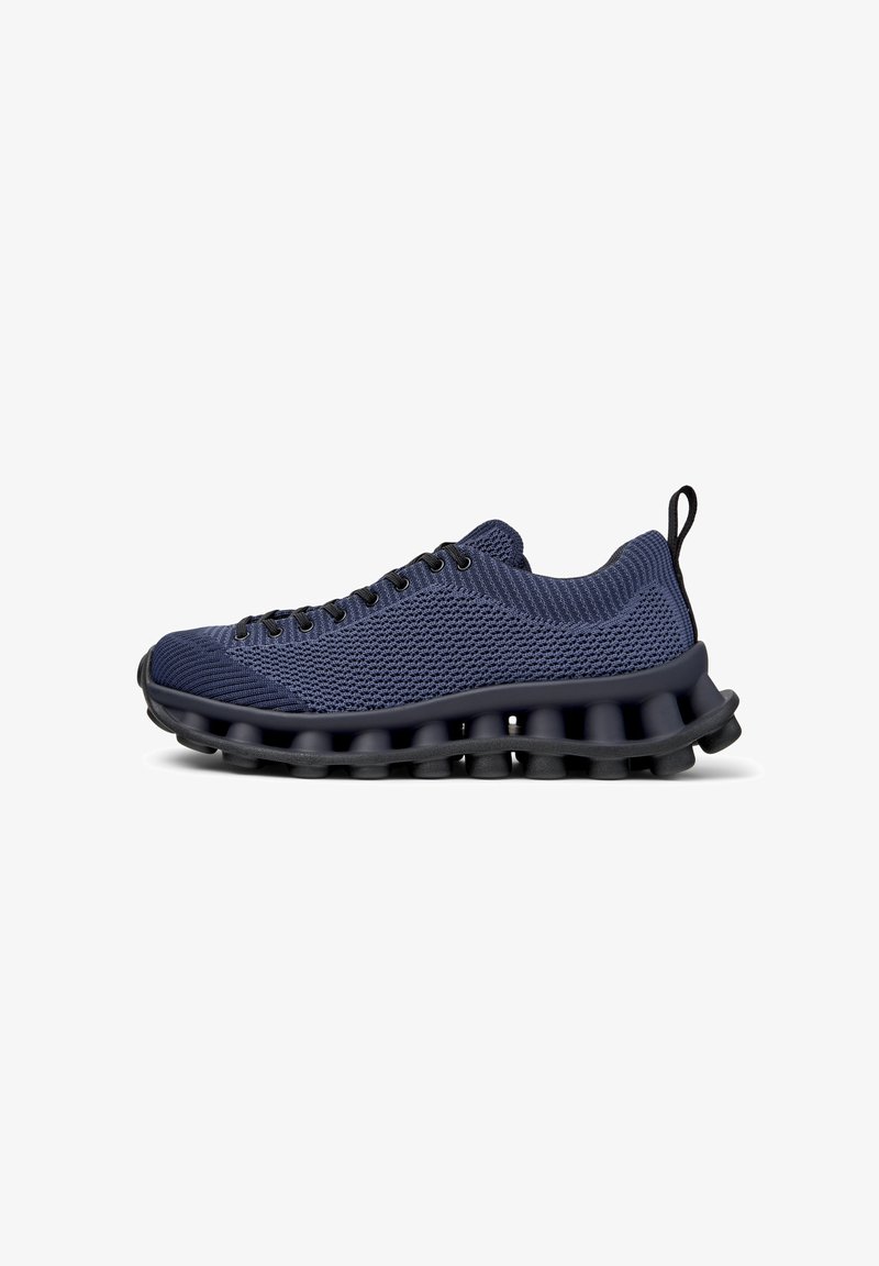Navy athletic shoe with a breathable knit upper and cushioned sole featuring a unique wave-like design for enhanced comfort and support.