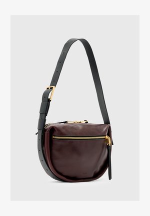 Borsa a tracolla in pelle di un profondo bordeaux con forma arrotondata. Dotata di una chiusura con zip dorata e un manico nero staccabile con dettagli in oro.