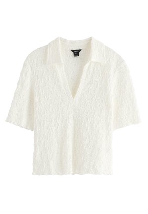 Hvid tekstureret kortærmet bluse med åben krave og V-hals, cropped længde, lavet af letvægtsstof.