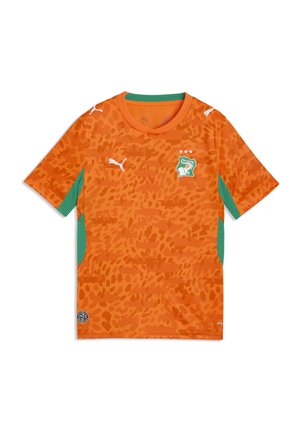 Maglia da calcio arancione con pannelli laterali verdi, un motivo leopardato sottile, loghi Puma e stemma della nazionale della Costa d'Avorio con tre stelle.
