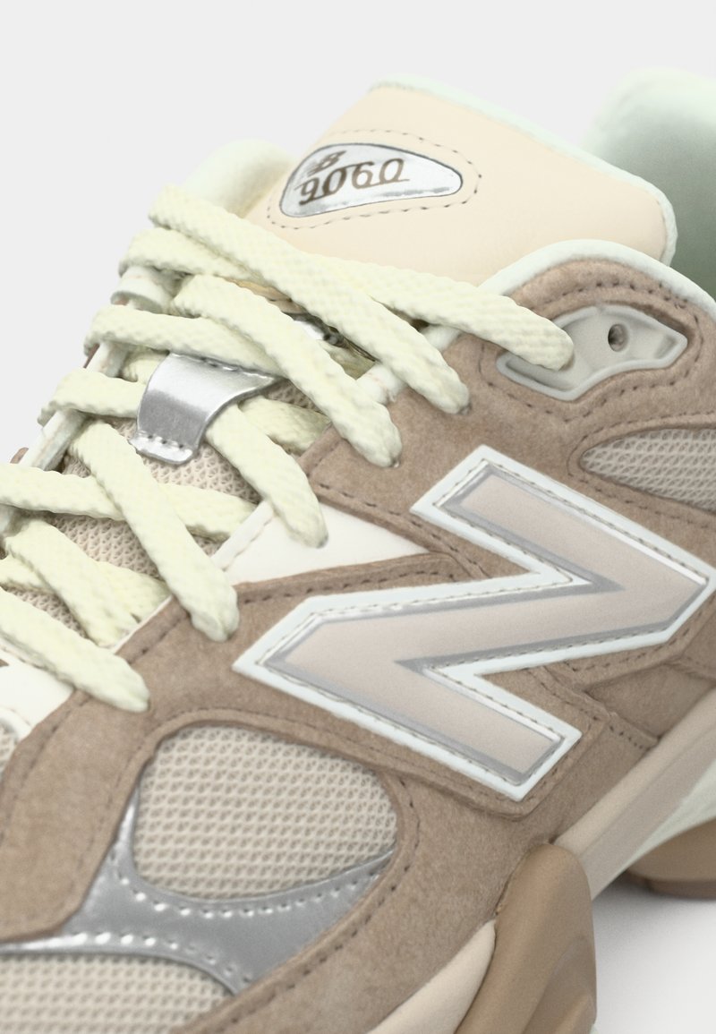 Beige en lichtgroene sneaker met een bovenwerk van mesh en suède, gestructureerde accenten, een ronde neus en reflecterende zilveren logodetail.