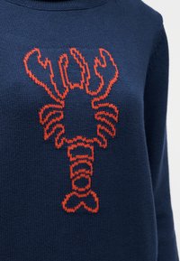 Πλεκτό πουλόβερ σε ναυτικό μπλε με μεγάλο πορτοκαλί σχέδιο αστακού στο κέντρο μπροστά.