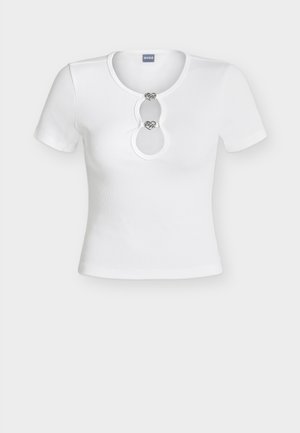 Λευκό κοντομάνικο τοπ με ριγέ ύφασμα και στρογγυλή λαιμόκοψη με άνοιγμα, ασφαλισμένο με δύο διακοσμητικά ασημένια κλεισίματα σε σχήμα καρδιάς.