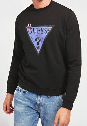 Sudadera negra con un gráfico triangular azul. Presenta logotipos coloridos, texto y diseños faciales en un estilo juguetón. Puños y dobladillo acanalados.