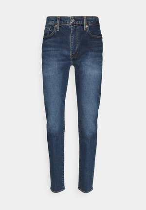 Jeans de mezclilla azul oscuro con un diseño ajustado, que cuentan con cinco bolsillos, un cierre frontal de botón y acentos de costura naranja.
