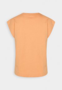 Oranžové tričko s krátkým rukávem, vyrobené z měkké bavlny. Má kulatý výstřih a volný střih s krátkými rukávy. Jednoduchá, jednobarevná varianta.