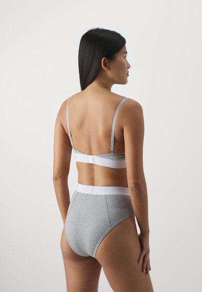 Sutiã cinza em algodão com alças ajustáveis e fecho de gancho; roupa interior cinza de cintura alta a condizer, com uma faixa branca e textura lisa.
