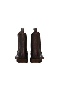 Bottines en cuir marron avec un dos cousu, des accents rouges et des tirettes, montées sur des semelles en bois avec une finition texturée.