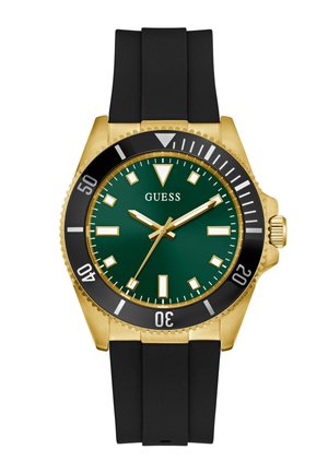 Montre Guess en or et noir avec cadran vert, lunette noire, index en or et bracelet en silicone noir, affichant 2:08:36.