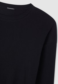 Maglietta nera a maniche lunghe con scollo rotondo. Realizzata in tessuto morbido, presenta cuciture minime e un'etichetta del marchio discreta.