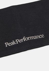 Crni šal od tkanine s rebrastom teksturom i izvezenim natpisom "Peak Performance" u srebrnoj niti. Jednostavan, pravokutni dizajn.