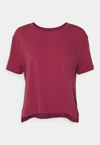Camiseta corta de manga en burdeos con cuello redondo, aberturas laterales y textura suave. Presenta un ajuste holgado y dobladillos cosidos.
