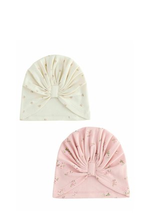 Zwei weiche Baumwoll-Babyturbane, eines in Creme und eines in Pink, beide mit kleinen Blumenmustern und versammelten, zentralen Knoten-Designs.