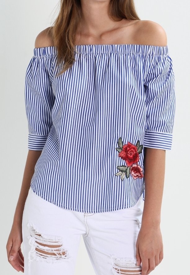 Blusa off-shoulder a righe blu e bianche con maniche corte, caratterizzata da ricami floreali rossi sul lato sinistro e una vestibilità rilassata.