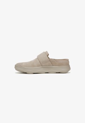 Beige suede slip-on shoe with a wide strap across the upper, rounded toe, and a sculpted light beige sole featuring a wave pattern.