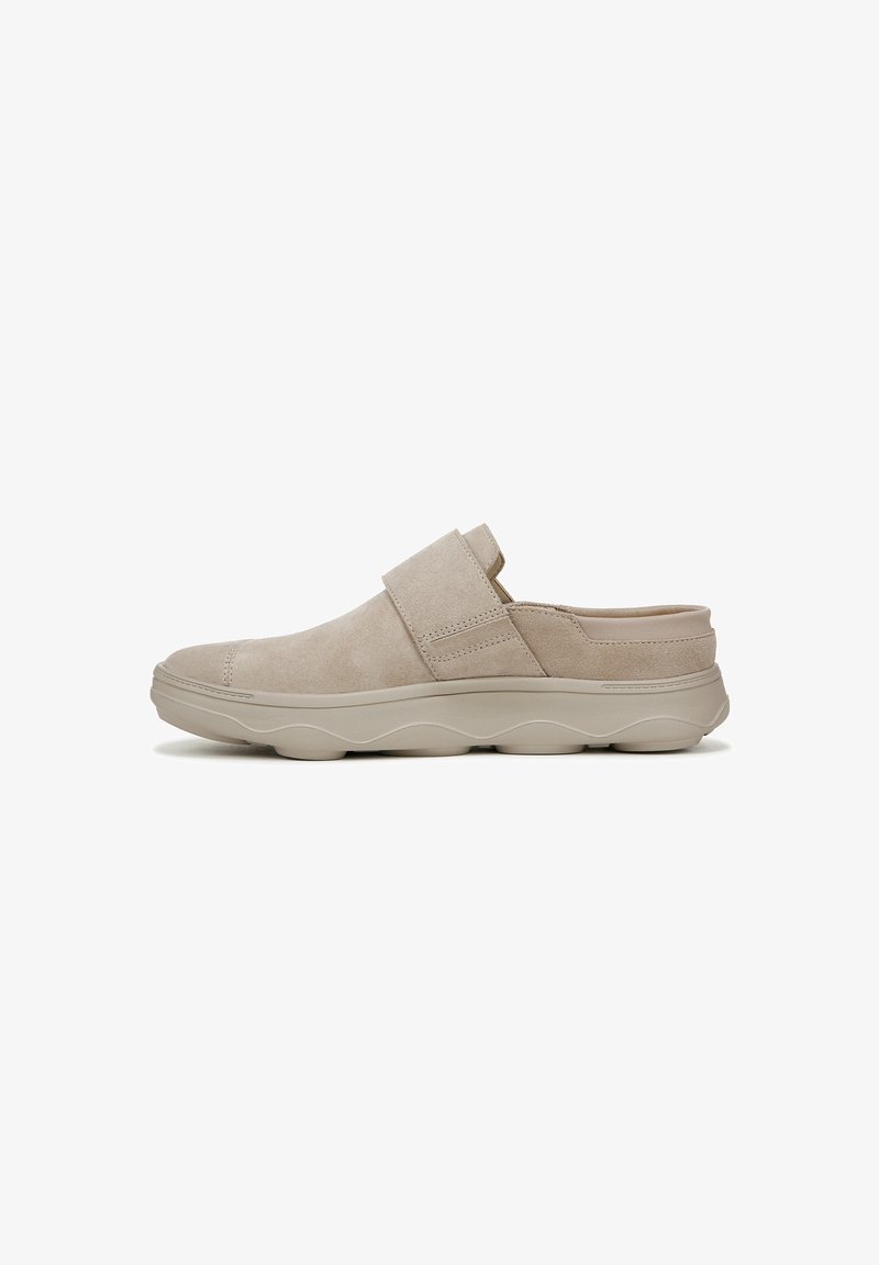 Chaussure slip-on en daim beige avec une large sangle sur le dessus, bout rond et semelle sculptée beige clair présentant un motif en vagues.