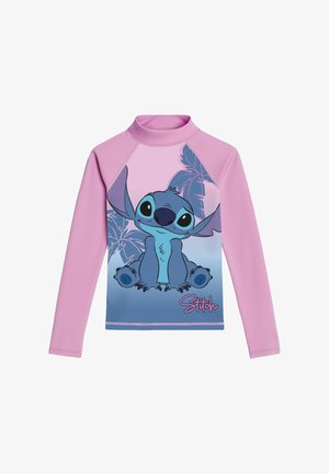 Maglia protettiva rosa a maniche lunghe per bambini con un grande personaggio Stitch blu seduto davanti a foglie di palma e testo "Stitch" in basso a destra.