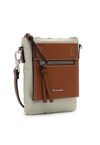 Hnědá a šedá crossbody taška vyrobená z texturovaného materiálu, má přední zipovou kapsu, detaily s třásněmi a černé akcenty. Součástí jsou stříbrné kovové prvky.