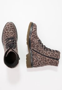 Par de botas de encaje con estampado de leopardo marrón, con cremallera lateral y suelas de caucho tan gruesas, sobre fondo blanco.
