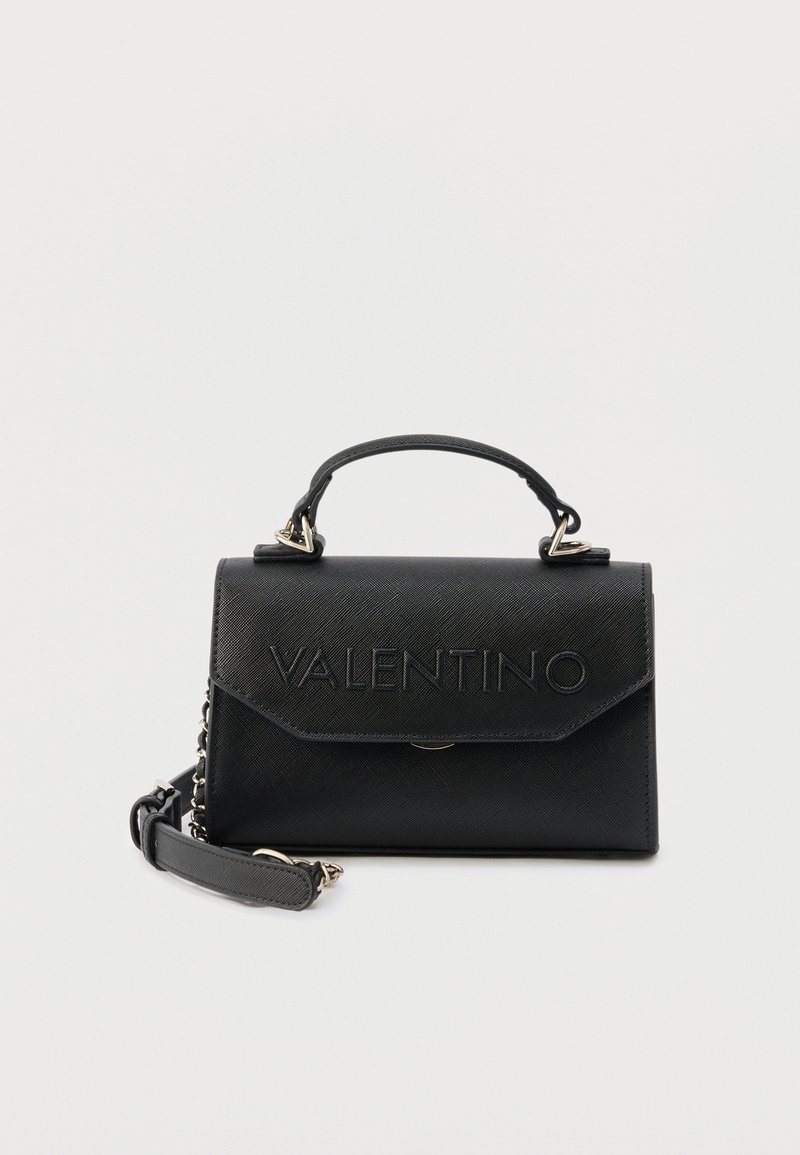 Μαύρη δερμάτινη τσάντα χειρός Valentino με πάνω λαβή, εμπρόσθιο καπάκι και αφαιρούμενο ιμάντα ώμου με αλυσίδα, σε λευκό φόντο.