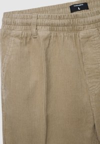 Pantaloni di velluto a coste color sabbia con elastico in vita, caratterizzati da righe verticali, tasche laterali e un'etichetta che indica la taglia L della Terranova.